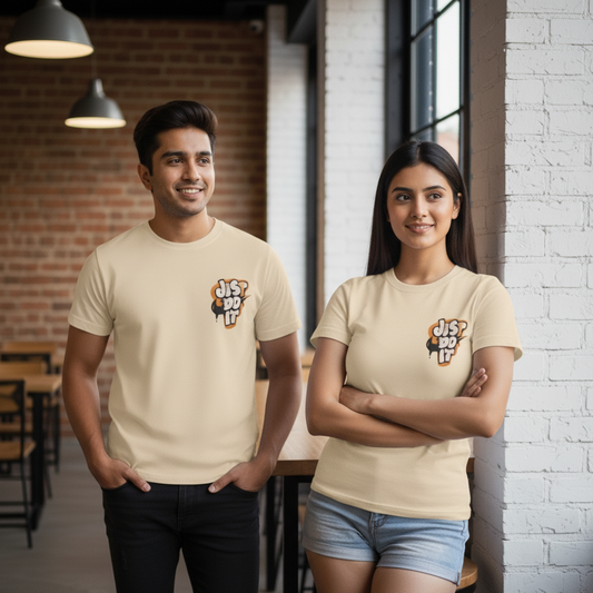 Two people wearing beige t-shirts with a logo and text, standing in a casual indoor setting.